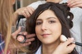 Master inflicts brush powder on the face of the girl, completes the day make-up in a beauty salon. Royalty Free Stock Photo