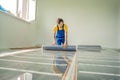 Master installs film warm floor in the room. Floor heating installation Royalty Free Stock Photo