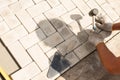 The master lays paving stones in layers. Garden brick pathway paving. Laying concrete paving slabs in house courtyard on sand Royalty Free Stock Photo