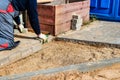 The master in lays paving stones in layers. Garden brick pathway paving by professional paver worker. Laying gray concrete paving Royalty Free Stock Photo