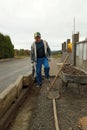 The master lays paving stones for the sidewalk and yard path