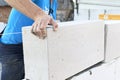 The master lays a wall of blocks. Builder builds a concrete wall made of cement blocks on the construction site of a residential