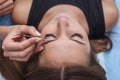 Master makeup corrects, and gives shape to pull out with forceps previously painted with henna eyebrows in a beauty salon.