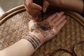 Master making henna tattoo on hand, closeup. Traditional mehndi Royalty Free Stock Photo