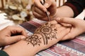 Master making henna tattoo on hand. Traditional mehndi Royalty Free Stock Photo