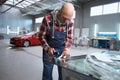Master male in the repair shop works with the windshield