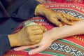 Master mehndi draws henna on a female hand Royalty Free Stock Photo