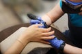 The master of nail service aligns the nails to the client with an electric machine