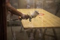 Master painter in a factory - industrial painting wood with spray gun. Soft focus