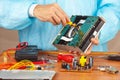 Master parses electronic device for repair in service workshop Royalty Free Stock Photo