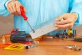 Master parses electronic hardware for checking in service workshop Royalty Free Stock Photo