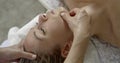 Master is performing face massage for adult woman, close-up of hands