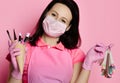 Master in pink medicine gloves, apron and white mask with nail varnish samples display and manicure equipment in waffle cone