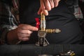 Master plumber connects brass fittings while repairing equipment. Close up of hands of the master during work in workshop