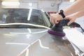 Master polishes car body with polishing machine