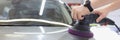 Master polishes car body with polishing machine