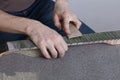 The master polishes the frets on the fretboard of the guitar. The fingerboard is protected by molar tape