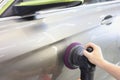 Master polishing car with sander to remove scratches closeup