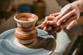 Master potter teaches the child how to make a jug out of clay