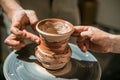 Master potter teaches the child how to make a jug out of clay