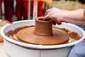 The master of pottery makes dishes from brown clay. Folk art