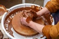 The master of pottery makes dishes from brown clay. Folk art