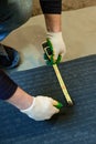 The master prepares a bituminous tape for installation, protection of a floor against moisture. Royalty Free Stock Photo