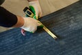 The master prepares a bituminous tape for installation, protection of a floor against moisture. Royalty Free Stock Photo