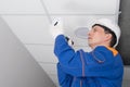 A master in a protective helmet for the maintenance of fire alarms, conducts an inspection in the residential sector Royalty Free Stock Photo