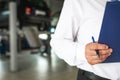 Master receptionist in a car service station with a tablet for recording repairs and maintenance. Repair area, telephone