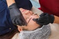 The master removes excess eyebrow makeup paint after the procedure Royalty Free Stock Photo