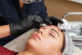 The master removes excess eyebrow makeup paint after the procedure Royalty Free Stock Photo