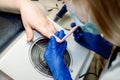 Manicure for a girl. Nail care in a beauty salon. Master removes shellac gel nails, which are exfoliated with sawing tool