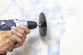 The master removes the stale paint from the wall using a grinding attachment on a drill Royalty Free Stock Photo