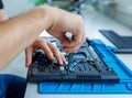 master repairs laptop, hands in glove, top view, first person view.