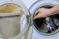 Master repairs washing machine with a screwdriver