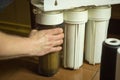 The master replaces dirty filters in the home water purification system. Human hands, filter, membrane Royalty Free Stock Photo