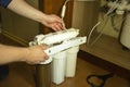 The master replaces dirty filters in the home water purification system. Human hands, filter, membrane Royalty Free Stock Photo