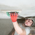 The master rubs the ceiling with a moisture-absorbing grater for lime plaster. Royalty Free Stock Photo