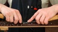 Luthier removes the frets of the guitar neck