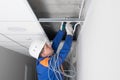 A master for setting up and installing wired Internet, fixes fasteners for cable installation Royalty Free Stock Photo