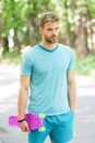 He is master of skateboard tricks. Guy carries penny board ready to ride. Man serious face carries penny board park Royalty Free Stock Photo