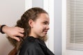 Master stylist takes care of the girl`s hair, for further laying of curly curls