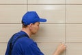 master-tiler blocks the seams between the tiles with beige cement grout