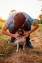 Master walking and hugging pug dog in autumn forest. Happy puppy sitting on grass. Dog love Royalty Free Stock Photo