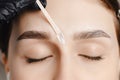 Master wax depilation of eyebrow hair in women, brow correction Royalty Free Stock Photo