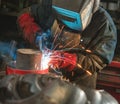 Master wearing a mask making welding factory