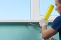 Master in white gloves, fulfills the bottom of the window sill foam, for tightness and insulation of the window sill in the house