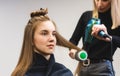 Master woman hairdresser dries the girl's hair with a hairdryer and combs after washing in the beauty salon. Royalty Free Stock Photo