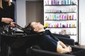 Master woman hairdresser gently washes the girl& x27;s hair with shampoo and conditioner before styling in a beauty salon. Royalty Free Stock Photo